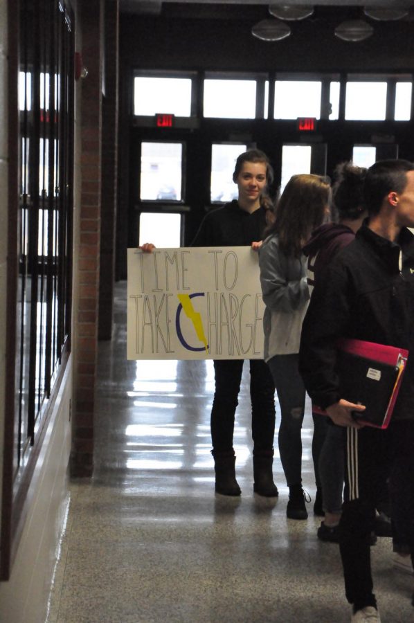 Helen Wargo holds a sign calling for change in guns laws and student safety.