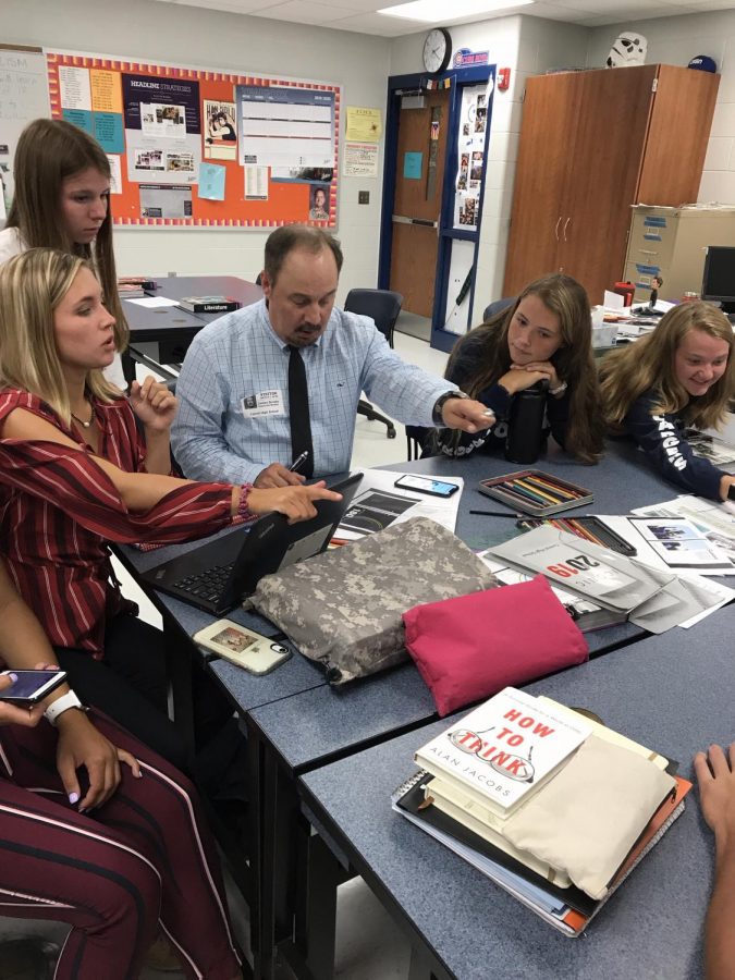 Jostens Designer Rick Brooks works with Editor-in-Chief Graham Ruselink, Student Life Editor Sydni Amick, Sports Editor Liz Knorr and Clubs Editor Kelsi Hoot on the cover of the 2020 Cavalier yearbook on August 26, 2019. Mr. Brooks comes to Carroll High School to help bring the editors vision to life every year. Photo by VM Smith. 