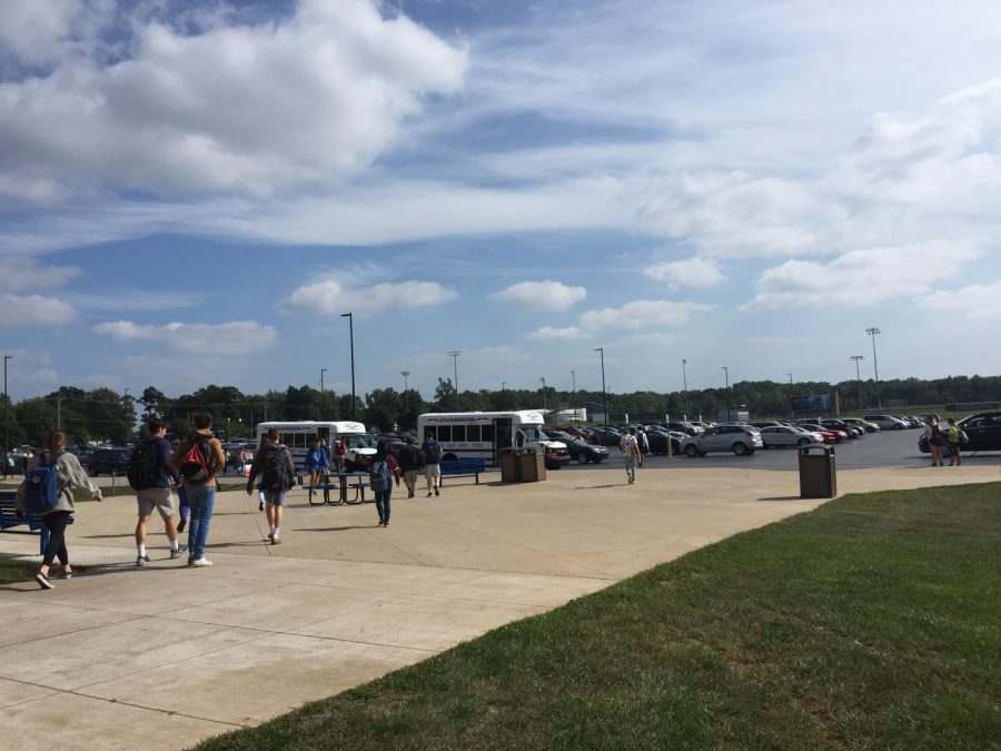 Students walk out of school at the end of the day into the school parking lot to drive home. 