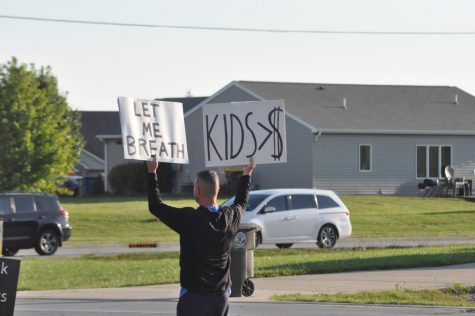 A protestors displays his signs to passing cars Wednesday morning at the corner of Bethel and Carroll roads. The protest was in response to the mask mandate from the NACS school board.