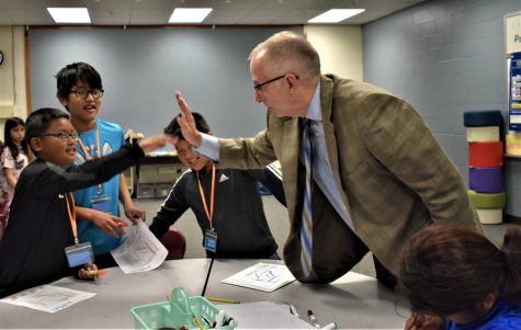 New superintendent Wayne Barker high-fives a student.