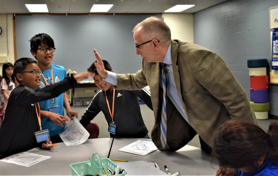 New superintendent Wayne Barker high-fives a student.