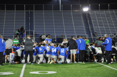The whole team kneels as they pray for a good game and keep Owen in their spirits.