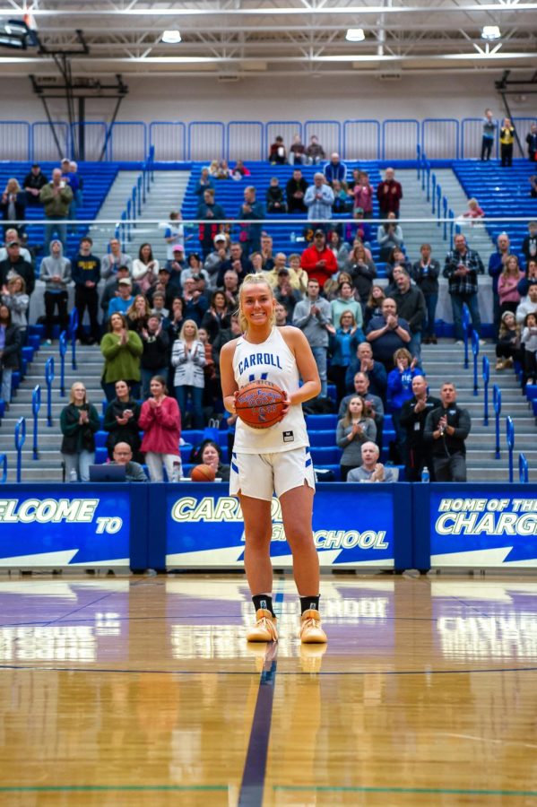 The+Friday+night+crowd+stands+to+honor+Senior+Taylor+Fordyce+scoring+1%2C000+points+in+her+high+school+career.+Photo+by+Avah+Crane.+