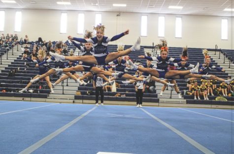 The Varsity Cheerleading team performs a split-jump as a group