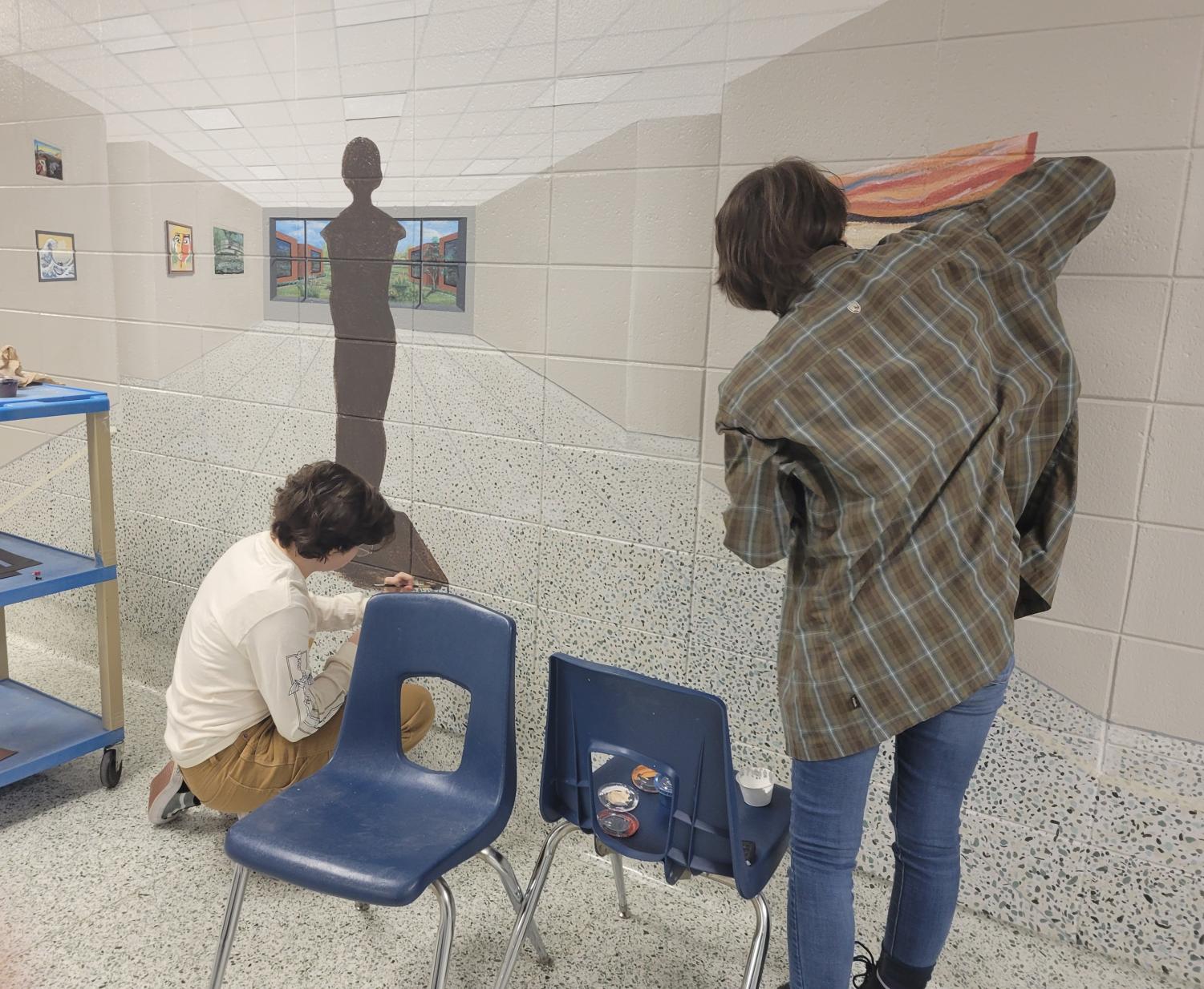 Renaissance club members Isabelle Fisher and Natalie Stiles working on a painting in the art hallway. Photo assisted by Kiara Borges. 