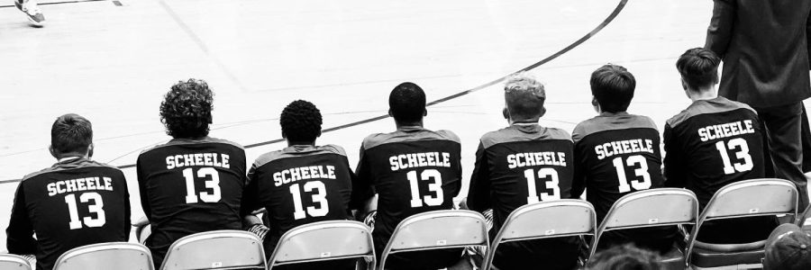 Carrolls+Boys+Basketball+team+watches+the+play+from+their+bench+at+Charger+Field+House+during+the+season+opening+game+on+November+23rd+in+their+new+shooting+shirts+to+honor+late+Carroll+QB%2FSenior+Owen+Scheele.+%0ACarroll+won+the+game+59-58.+