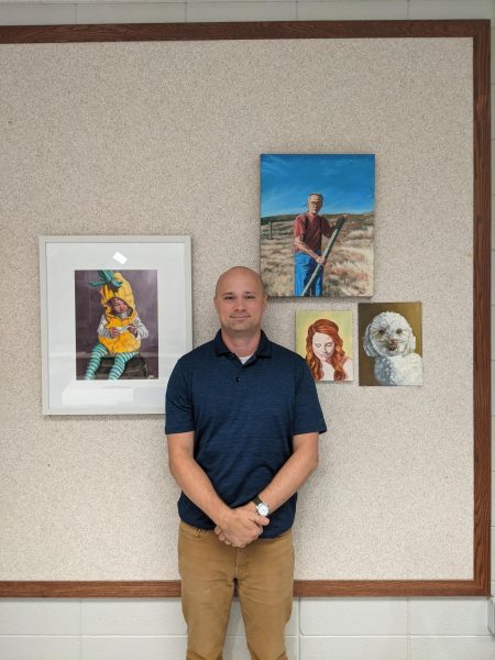 Weimer poses with pictures he painted of his family