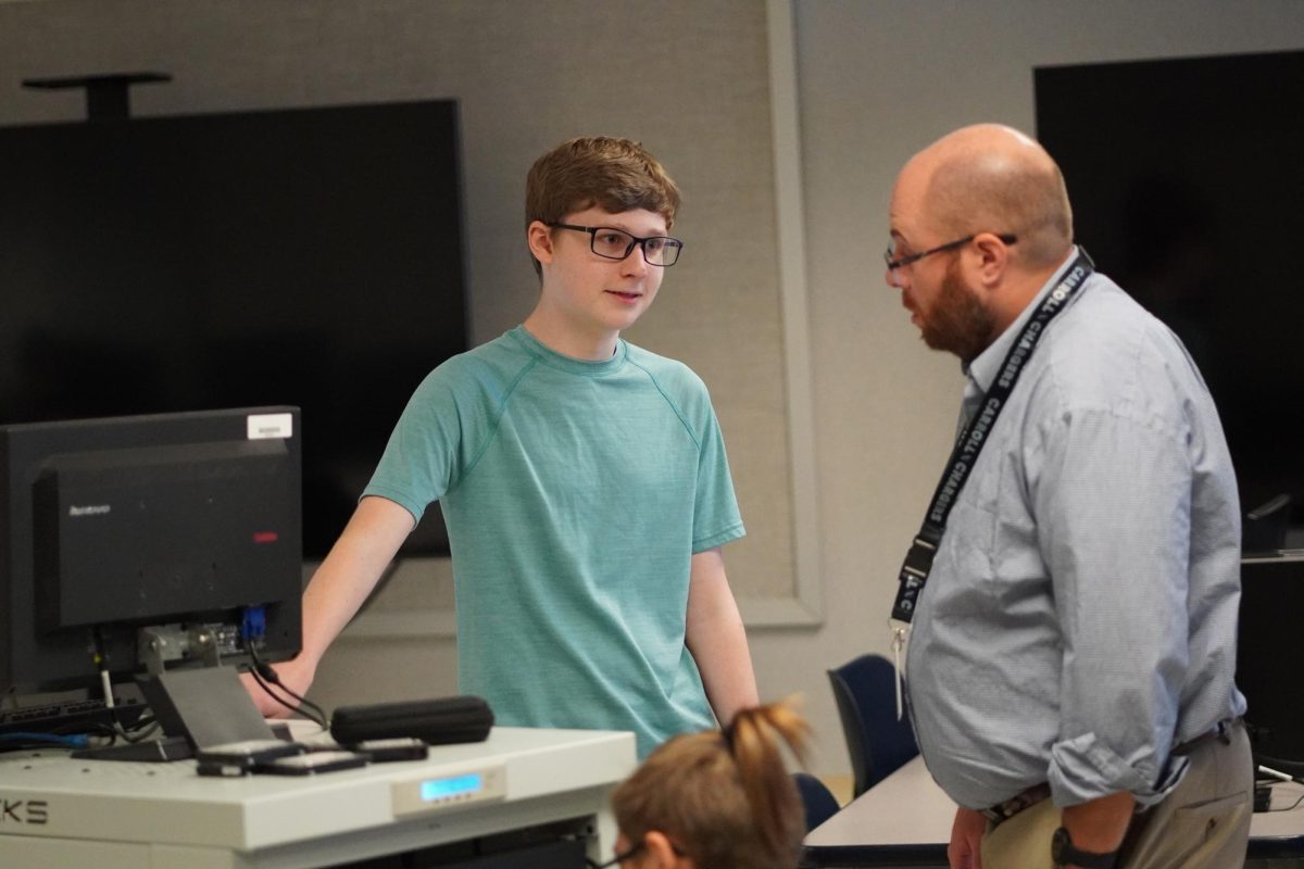 Mr. Matthew Arnold helps a couple of students works on their computer programs. Arnold started working at the high school on August 19. 