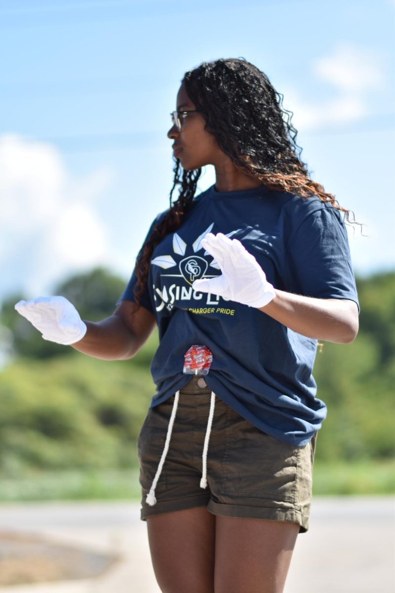 Senior Drum Major Oiza Momoh warms up the Charger Pride Marching Band before the band marches in the Huntertown Days Parade. 