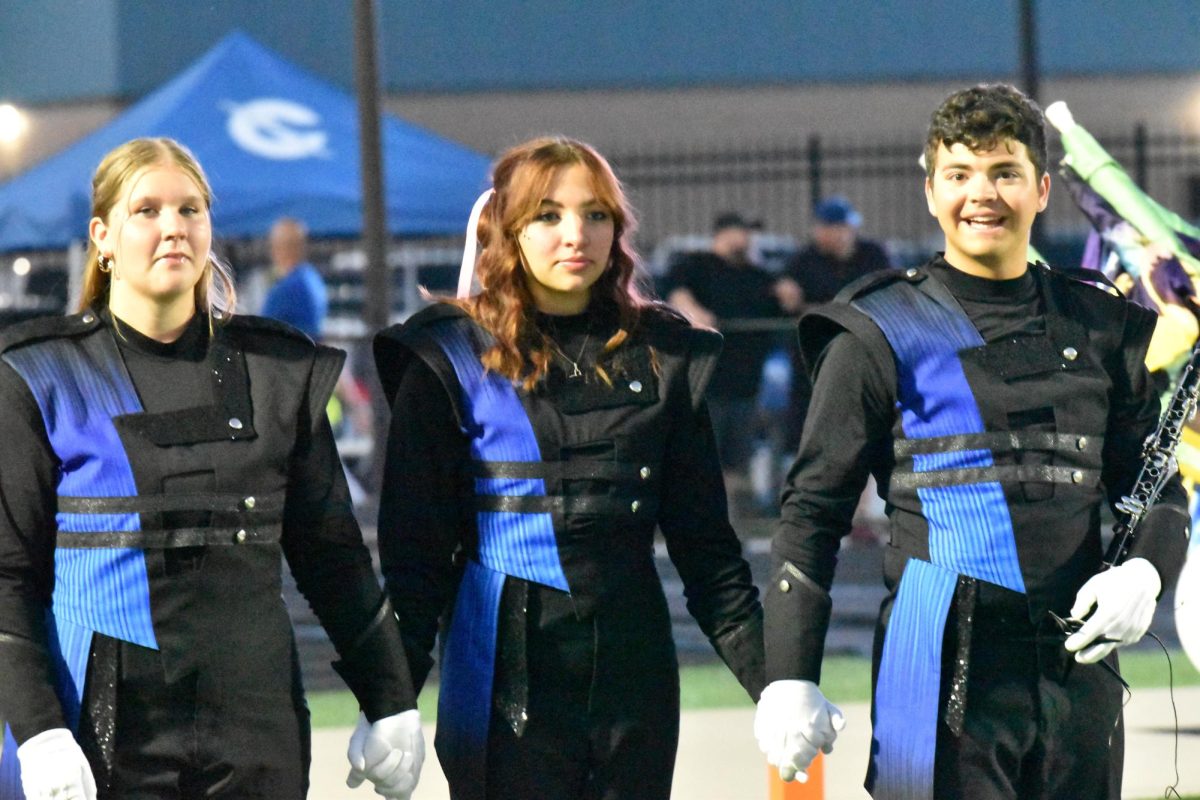 Drum Majors Senior Leah Goleeke, junior Natalie Gerber and Senior Gavin Coudron lead the marching band onto the field. 