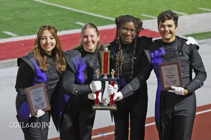 Drum Majors junior Natalie Gerber, Seniors Leah Goleeke, Ozia Momoh and  Gavin Coudron carry the trophy from their win at Goshen High School. 