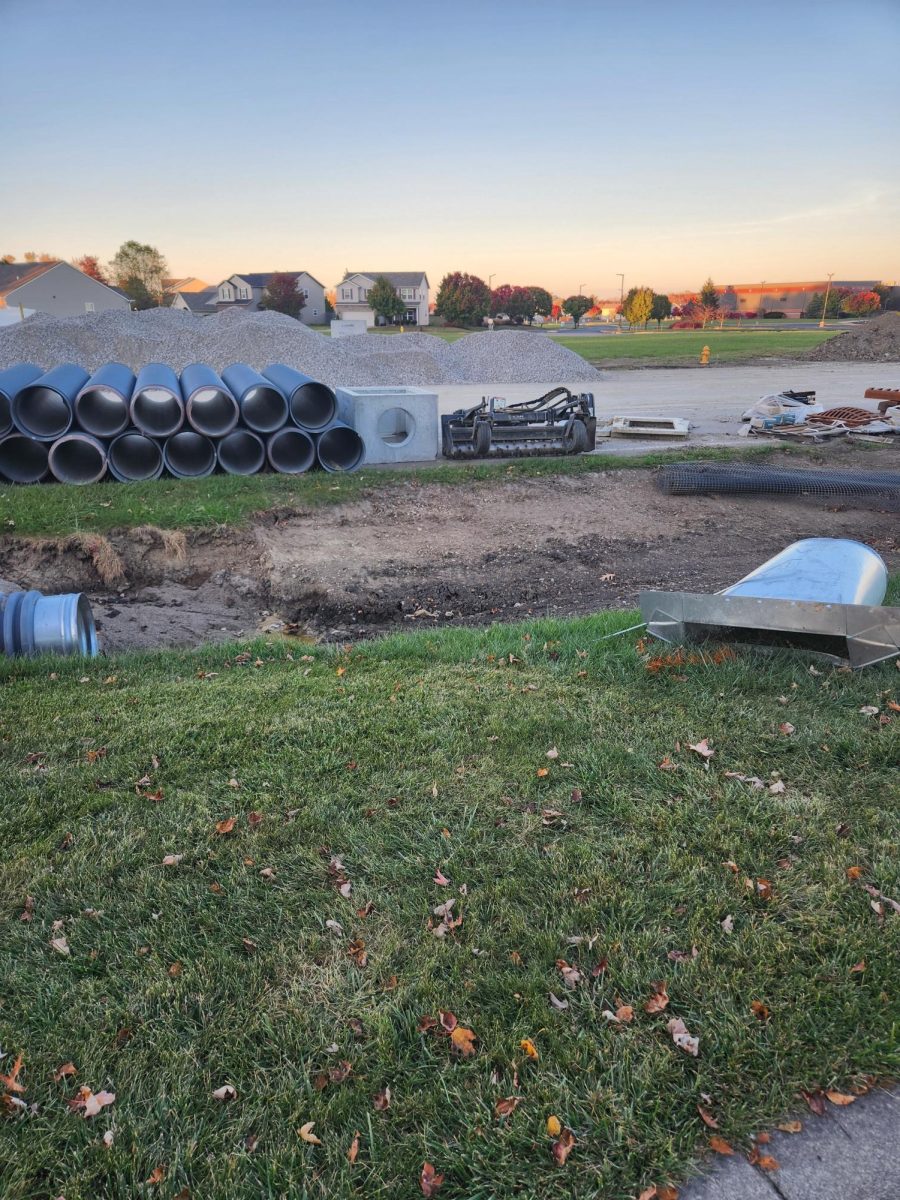 Culverts and other drainage materials spread throughout road right next to walking path. The construction site is easily assessable and a risk to pedestrians and their pets.