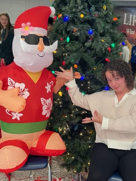 Rebecca Kiplinger posing with Santa Claus in the 10-12 Commons 